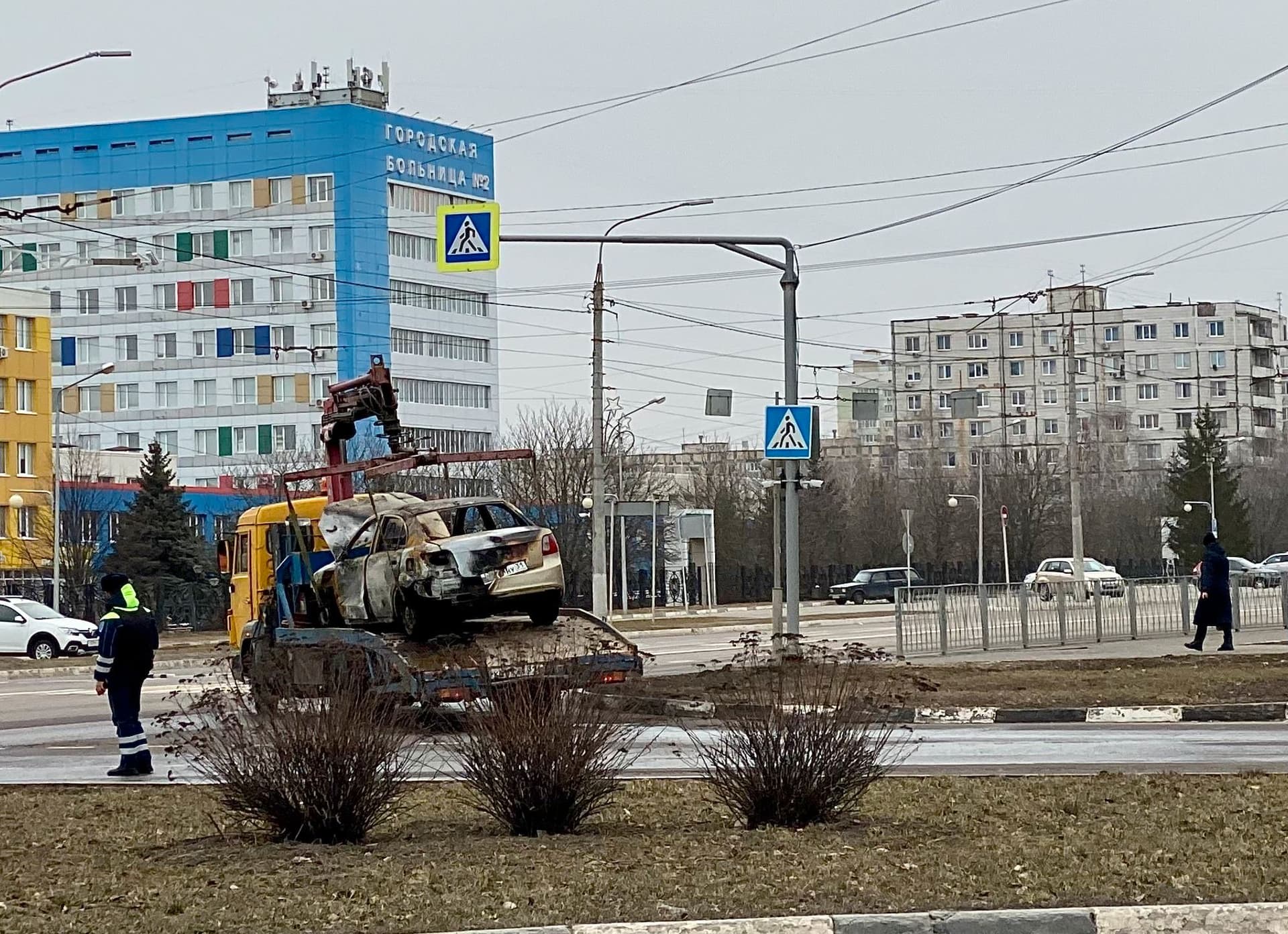 Municipal workers haul away cars damaged in the shelling