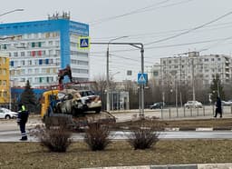 Municipal workers haul away cars damaged in the shelling