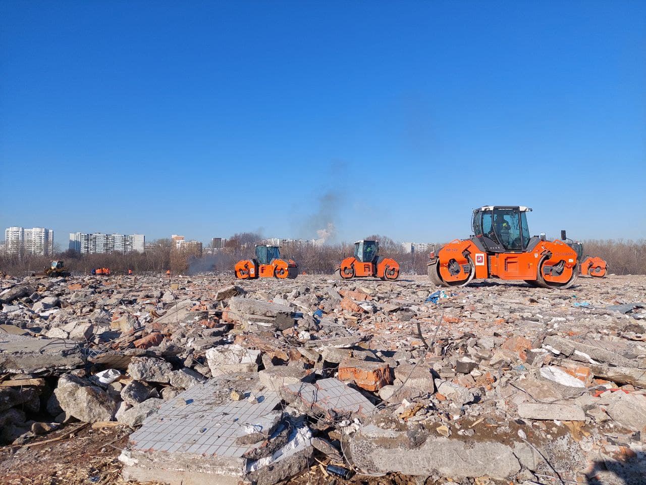 Техника выравнивает рельеф, засыпая слой строительного мусора, в том числе крупные обломки снесенных по реновации домов