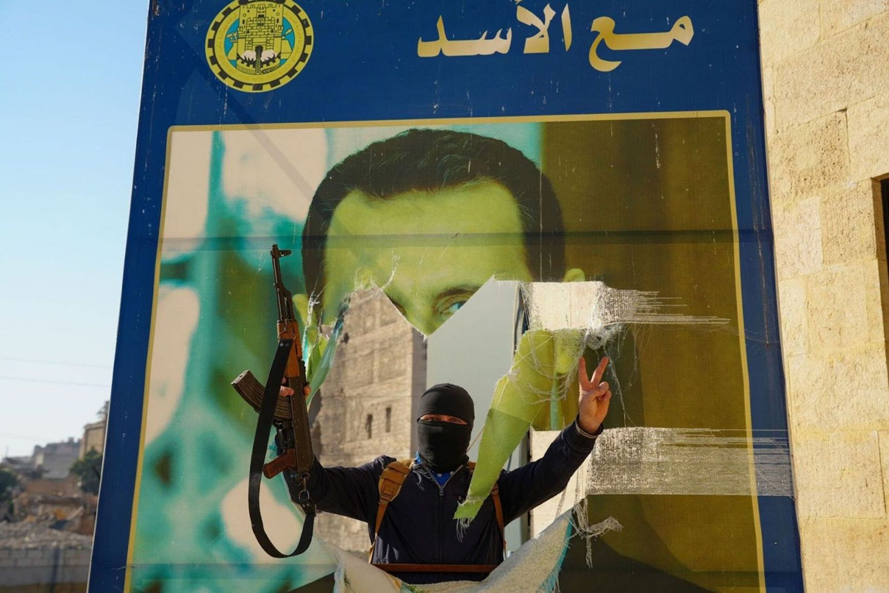 Syrian rebels tear down a poster of Bashar al-Assad in Aleppo on Nov. 30, 2024, following the city’s capture in a surprise offensive.