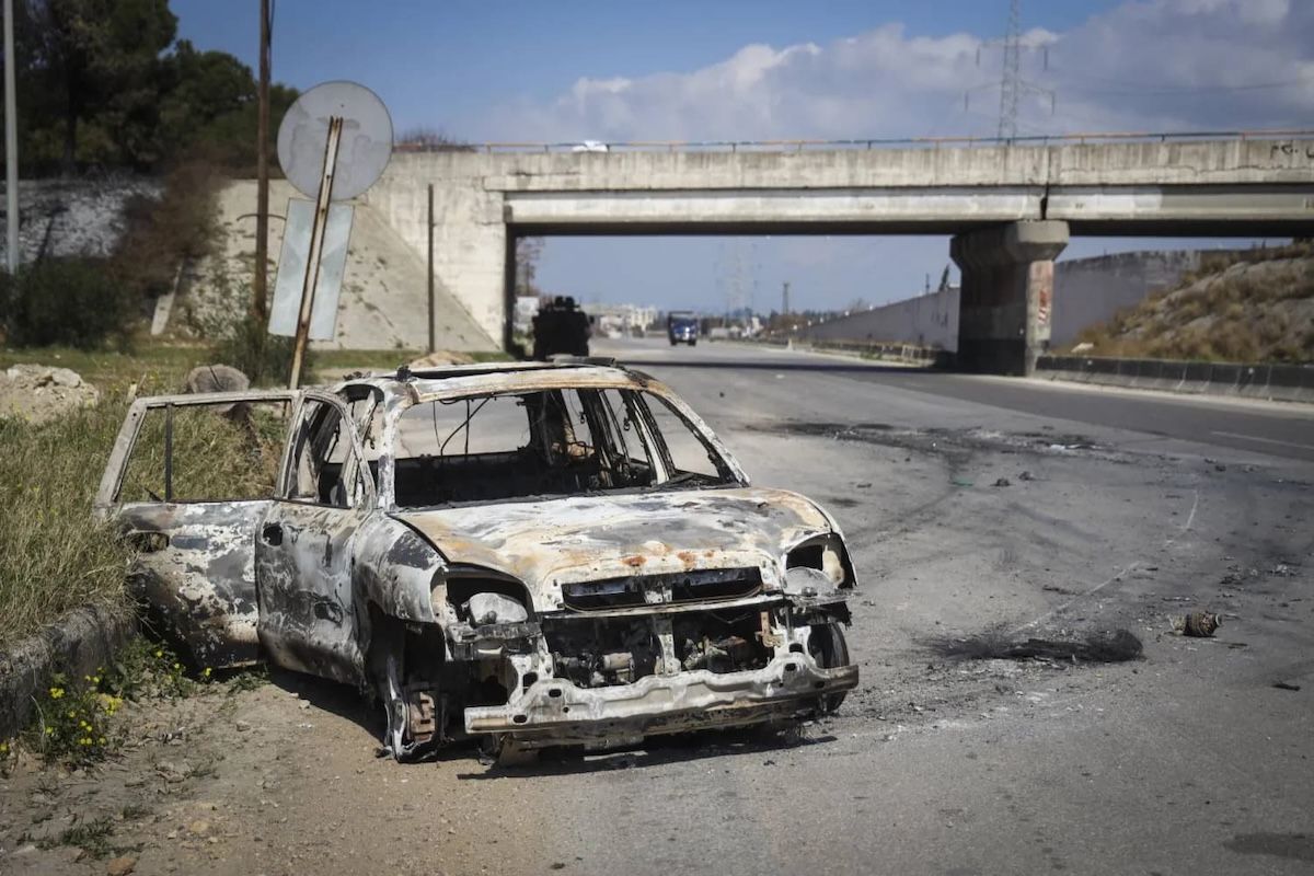 A car burned during clashes in Latakia