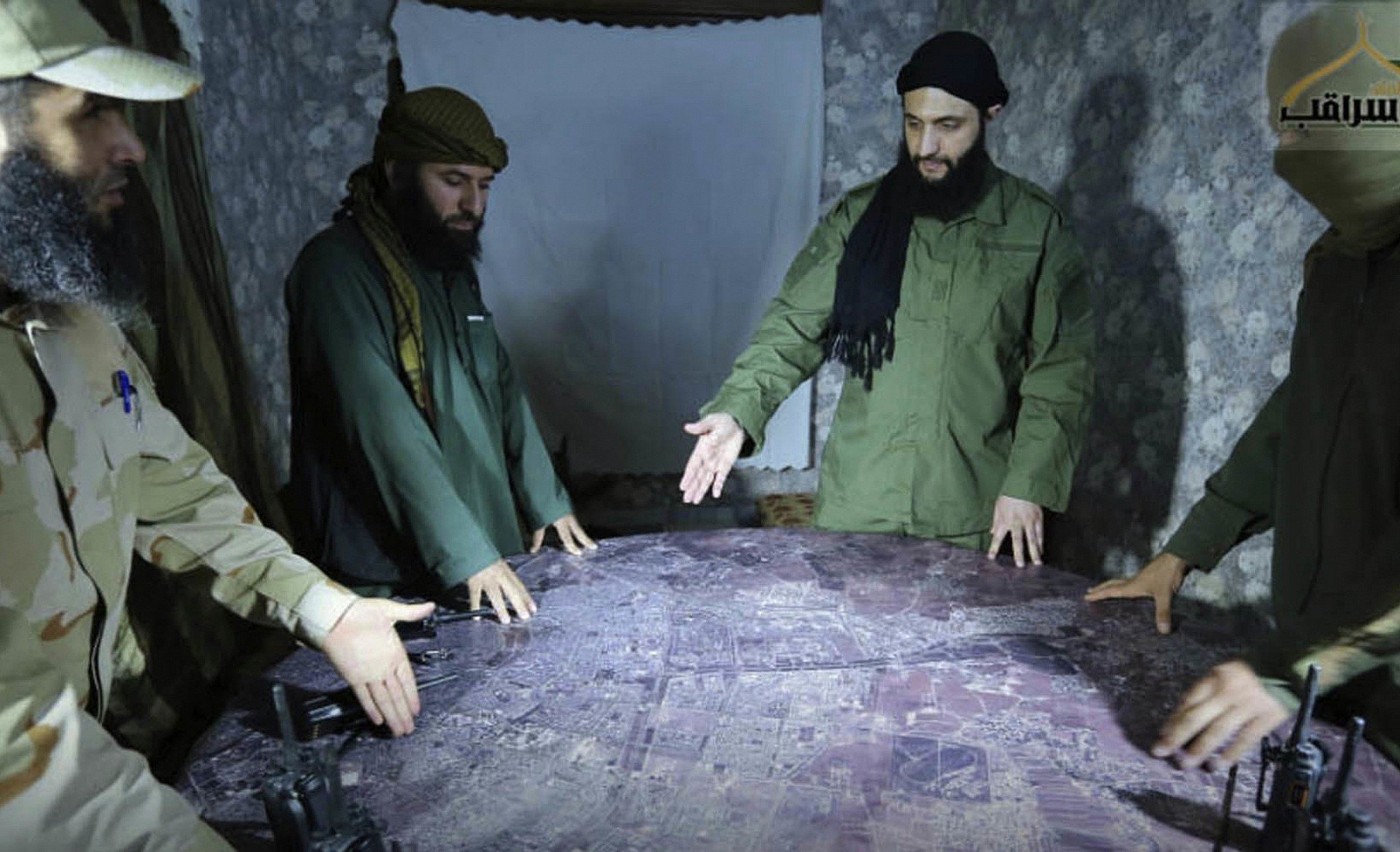 Ahmad al-Sharaa (second from right), then known by his nom de guerre Abu Mohammad al-Julani, discussing battlefield details with field commanders over a map in Aleppo, Syria, in an undated photo released in 2016. Photo: AP